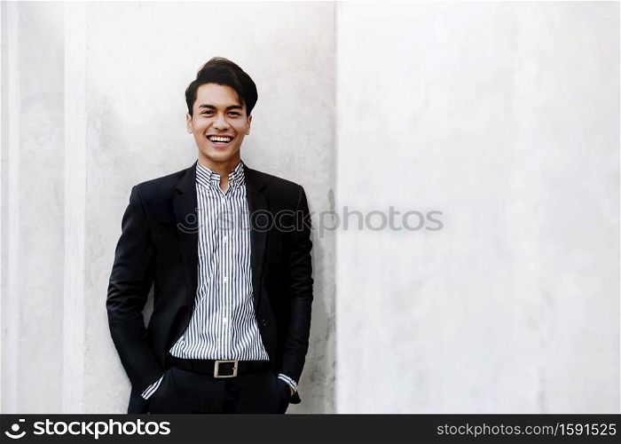 Portrait of Smiling Young Asian Businessman in Casual Suit. Standing in the City. Looking at Camera. a Happy Friendly Man