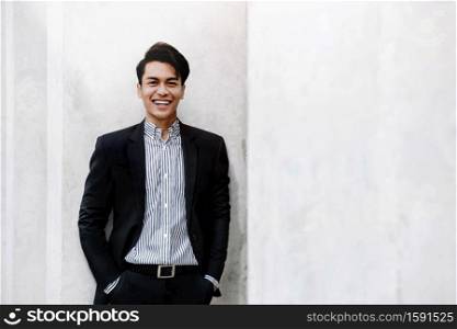 Portrait of Smiling Young Asian Businessman in Casual Suit. Standing in the City. Looking at Camera. a Happy Friendly Man