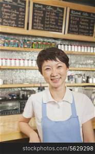 Portrait of smiling young barista in coffee shop, Beijing