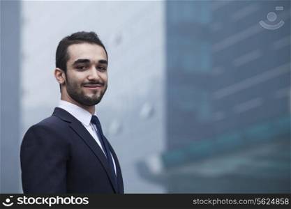 Portrait of smiling young businessman, outdoors, business district