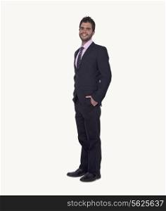 Portrait of smiling young businessman with hands in his pockets, studio shot, full length