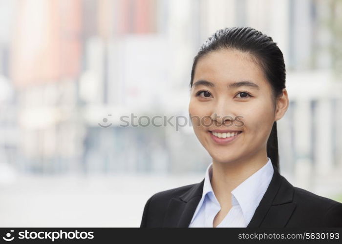 Portrait of smiling young businesswoman, head and shoulders