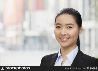 Portrait of smiling young businesswoman, head and shoulders