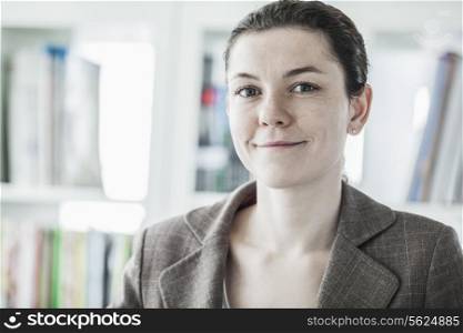 Portrait of smiling young businesswoman looking at the camera, head and shoulders