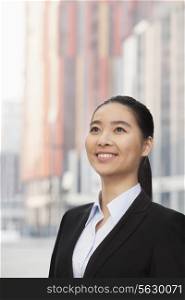 Portrait of smiling young businesswoman, looking up