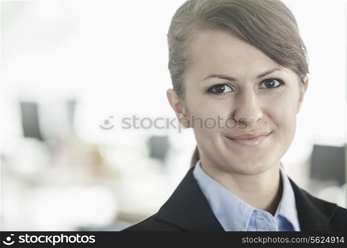 Portrait of smiling young businesswoman with bangs looking at the camera, head and shoulders