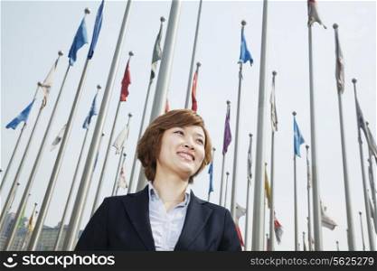 Portrait of smiling young businesswoman with flags