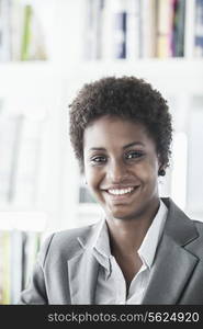 Portrait of smiling young businesswoman with short hair looking at the camera, head and shoulders