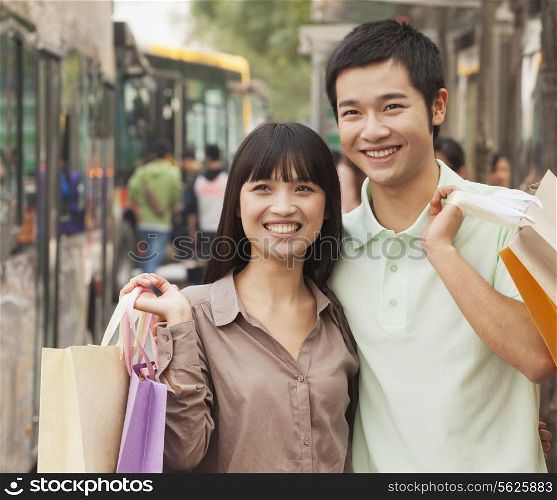 Portrait of smiling young couple at the bus stop, Beijing, China