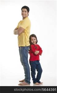 Portrait of smiling young father and daughter standing over white background