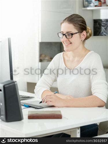 Portrait of smiling young female graphic designer working at modern office. Portrait of smiling female graphic designer working at modern office