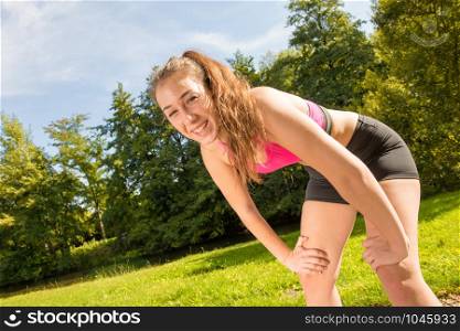 Portrait of smiling young fit woman outdoors
