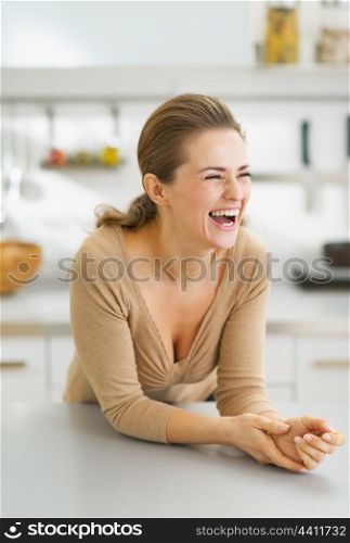 Portrait of smiling young housewife in modern kitchen