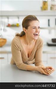 Portrait of smiling young housewife in modern kitchen