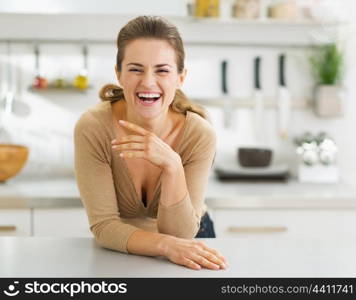 Portrait of smiling young housewife in modern kitchen