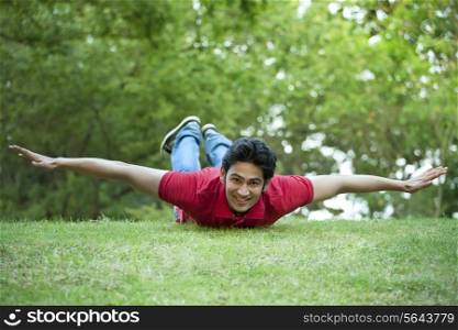 Portrait of smiling young man lying on grass
