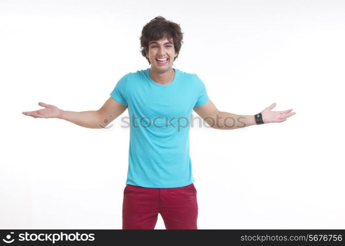 Portrait of smiling young man standing arms outstretched over white background