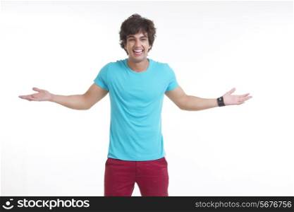 Portrait of smiling young man standing arms outstretched over white background