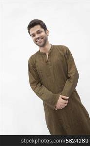 Portrait of smiling young man wearing traditional clothing from Pakistan, studio shot