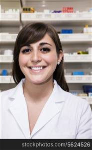 Portrait of smiling young pharmacist looking at the camera in a pharmacy