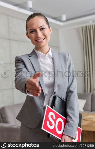 Portrait of smiling young saleswoman greeting while standing in apartment