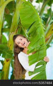 Portrait of smiling young woman among tropical palms
