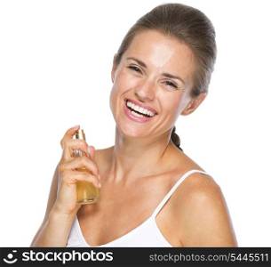 Portrait of smiling young woman applying perfume