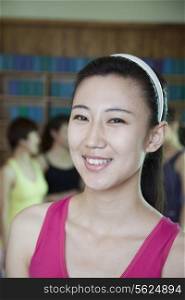 Portrait of smiling young woman in a yoga studio