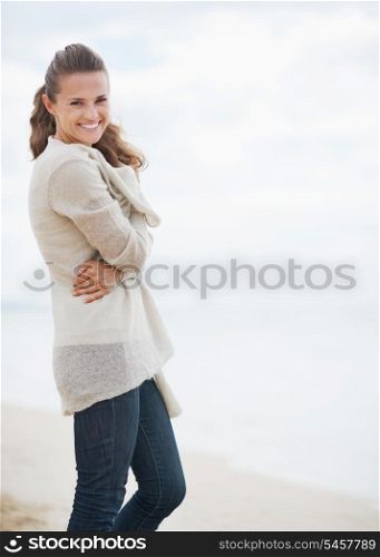 Portrait of smiling young woman in sweater on beach