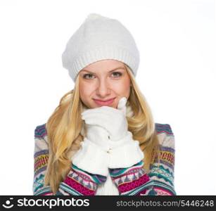 Portrait of smiling young woman in winter clothes warming hands
