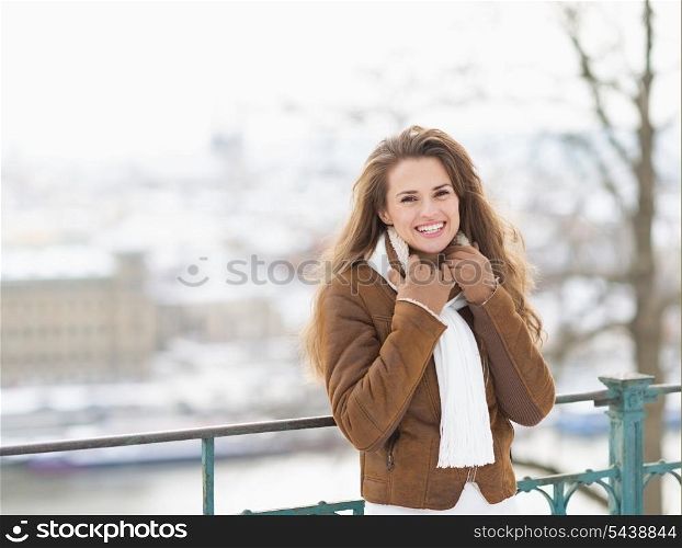 Portrait of smiling young woman in winter jacket outdoors