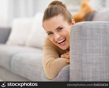 Portrait of smiling young woman looking out from divan