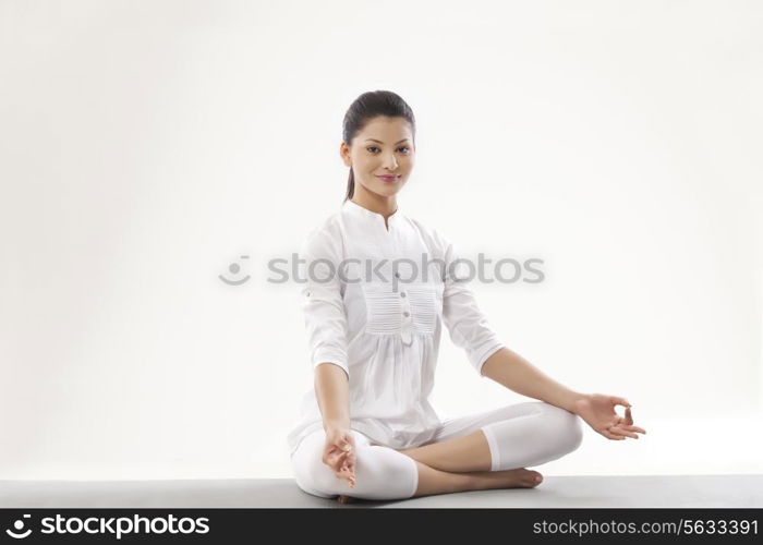 Portrait of smiling young woman meditating