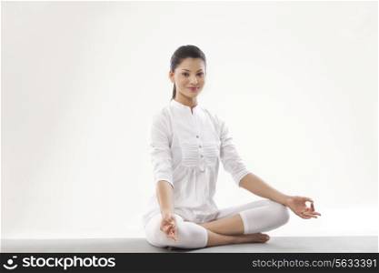 Portrait of smiling young woman meditating
