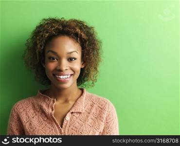 Portrait of smiling young woman on green background.
