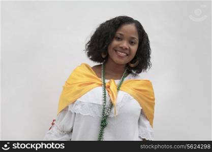 Portrait of smiling young woman wearing traditional clothing from the Caribbean, studio shot