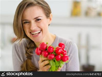 Portrait of smiling young woman with bunch of radishes