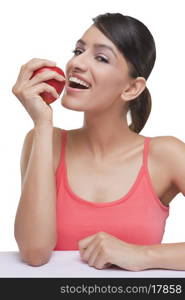 Portrait of smiling young woman with fresh apple over white background