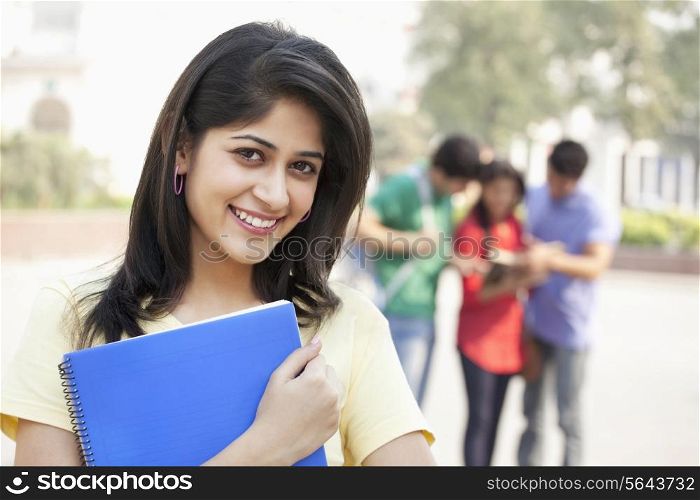 Portrait of smiling young woman with friends in the background