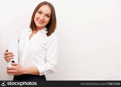 Portrait of smilng businesswoman is standing with a folder over white isolated background
