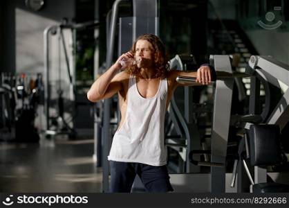 Portrait of sportsman having rest breathing heavily after effective workout and cardio training at sport gym. Portrait of sportsman having rest breathing heavily looking forward