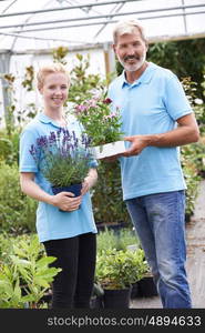 Portrait Of Staff At Garden Center Holding Plants