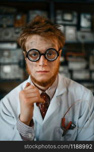 Portrait of strange male scientist in glasses, engineer in laboratory. Electrical testing tools on background. Lab equipment, engineering workshop