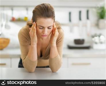 Portrait of stressed young housewife in kitchen