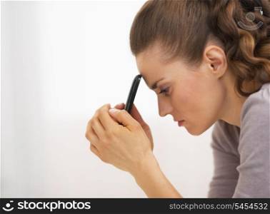 Portrait of stressed young woman with mobile phone