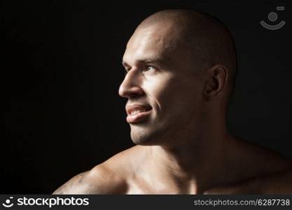 portrait of strong smiling man isolated on black background with copyspace