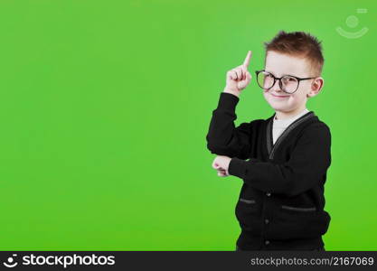 Portrait of stylish little boy with finger pointed up. Little child in glasses has idea. Kid isolated on blue blackboard. Success, bright idea, creative ideas and innovation technology concept. Portrait of stylish little boy with finger pointed up. Little child in glasses has idea. Kid isolated on blue blackboard. Success, bright idea, creative ideas and innovation technology concept.