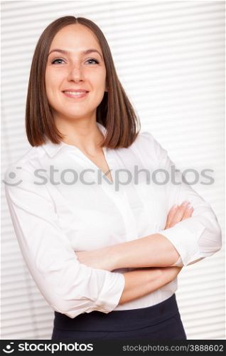 Portrait of successful brunette businesswoman with crossed hands over white isolated background