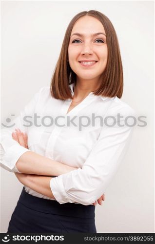 Portrait of successful brunette businesswoman with crossed hands over white isolated background