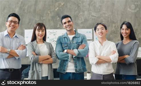 Portrait of successful businessman and businesswoman smart casual wear looking at camera and smile, arms crossed in creative office workplace. Diverse Asia male and female stand together at startup.